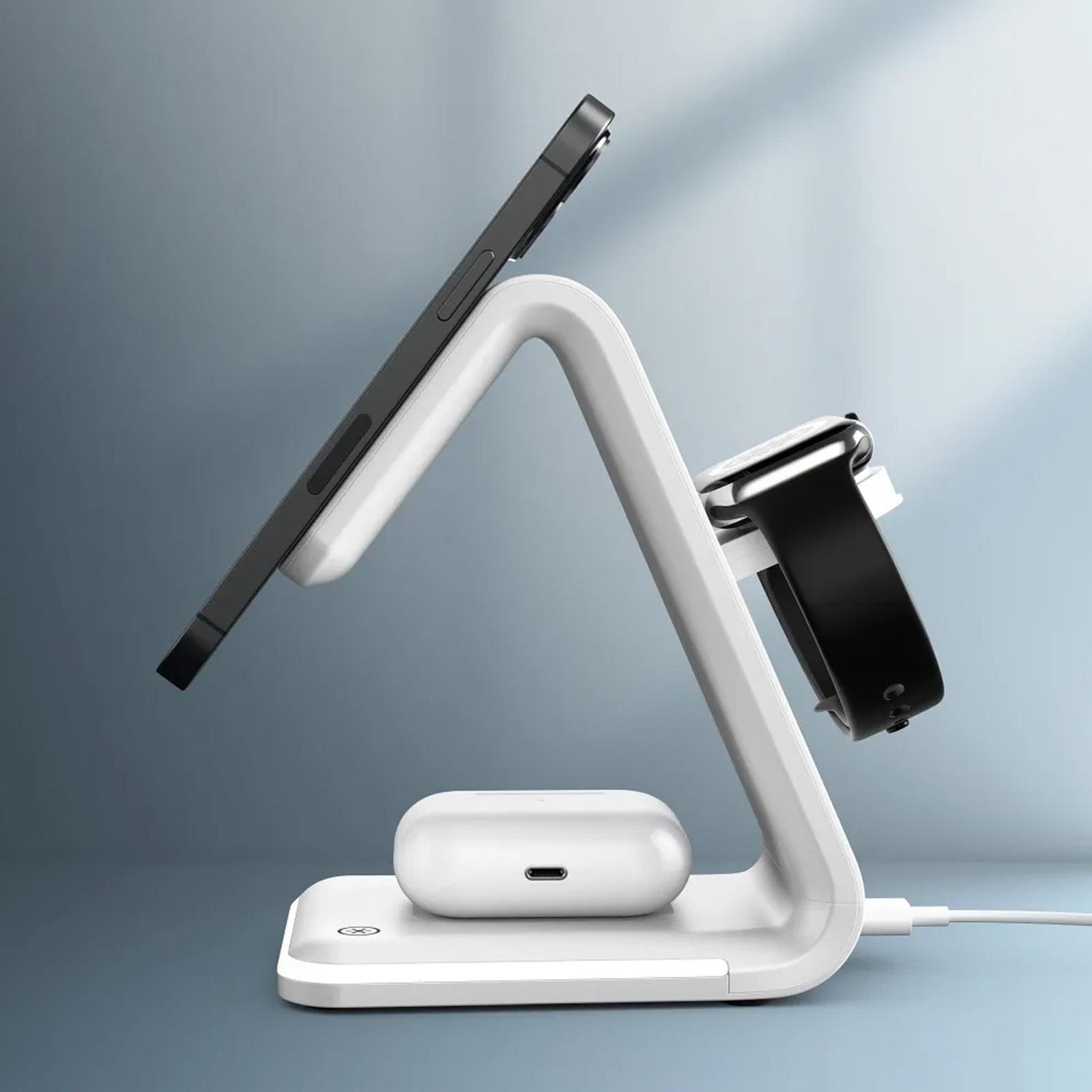 Weiße Ladestation aus Kunststoff mit iPhone, Apple Watch und AirPods, Seitenansicht.