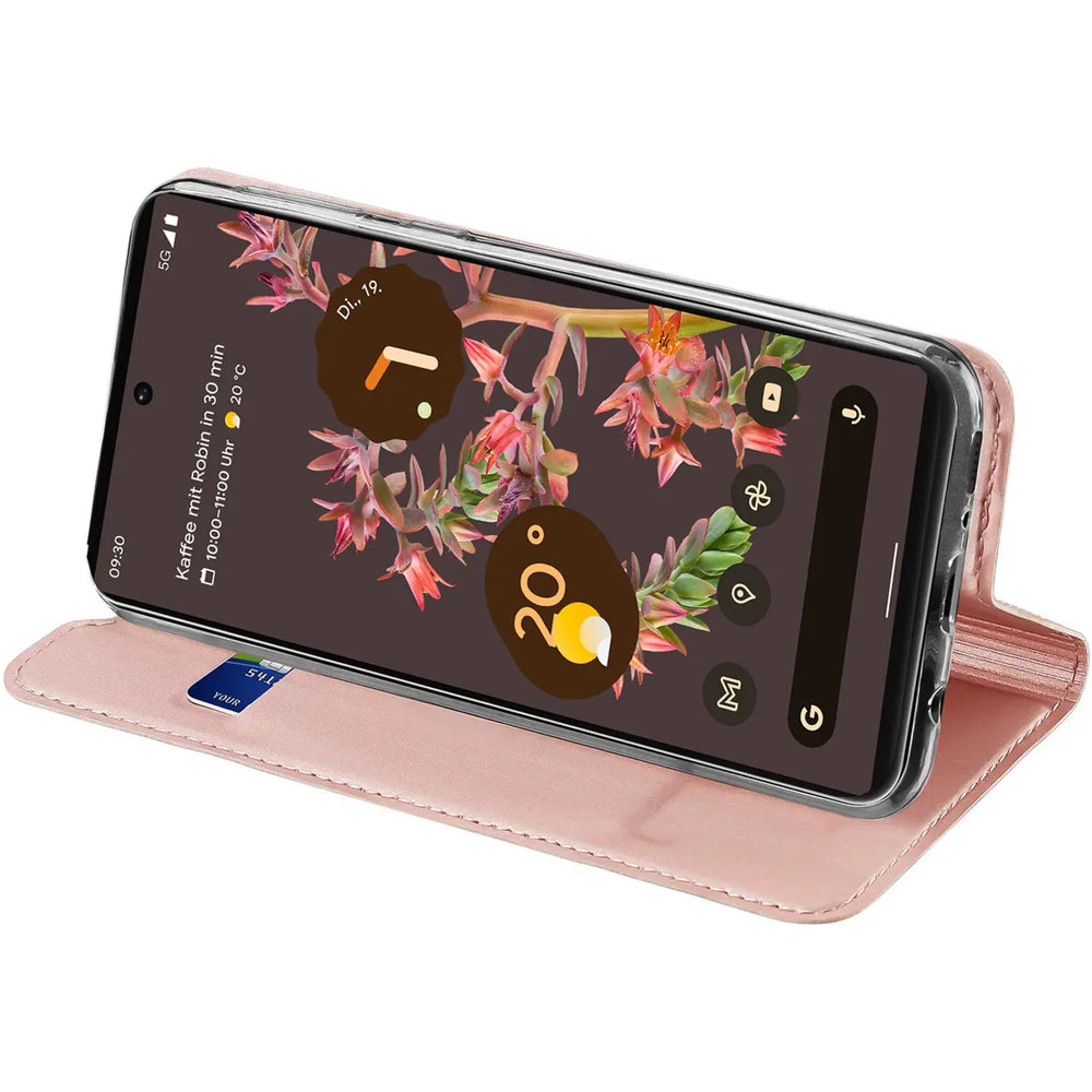 Google Pixel 6a in geöffneter, rosafarbener Metallic-Flip-Hülle aus Kunstleder, schräg von oben. Eine Karte steckt im Fach.