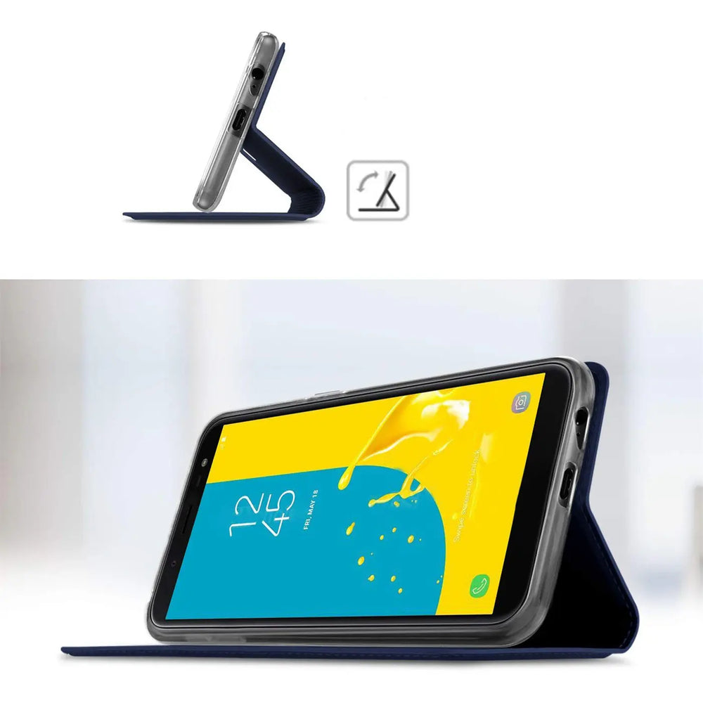 Samsung Galaxy J6 2018 in dunkelblauer Metallic Flip Hülle, als Ständer aufgestellt, schräg von vorn.