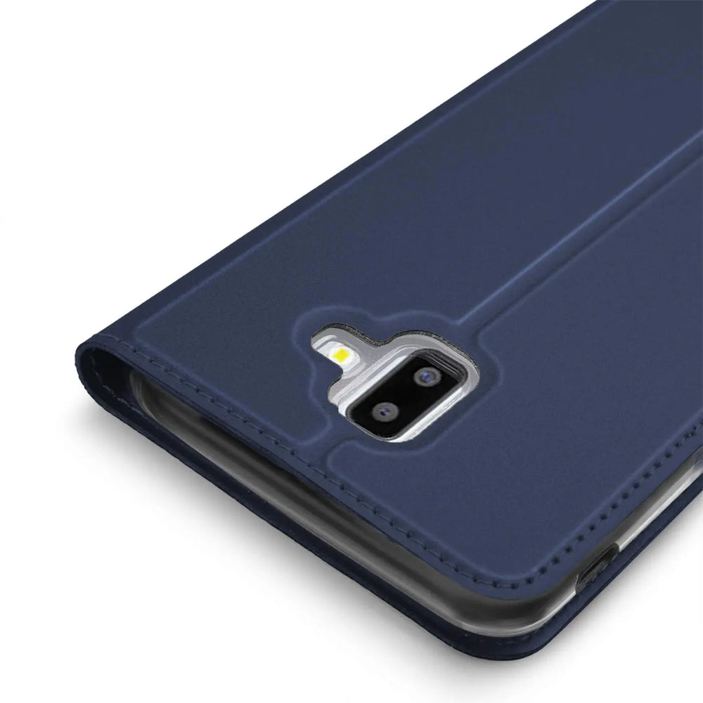 Nahaufnahme einer dunkelblauen Metallic Flip Hülle aus Kunstleder für Samsung Galaxy J6 Plus, schräg von oben.