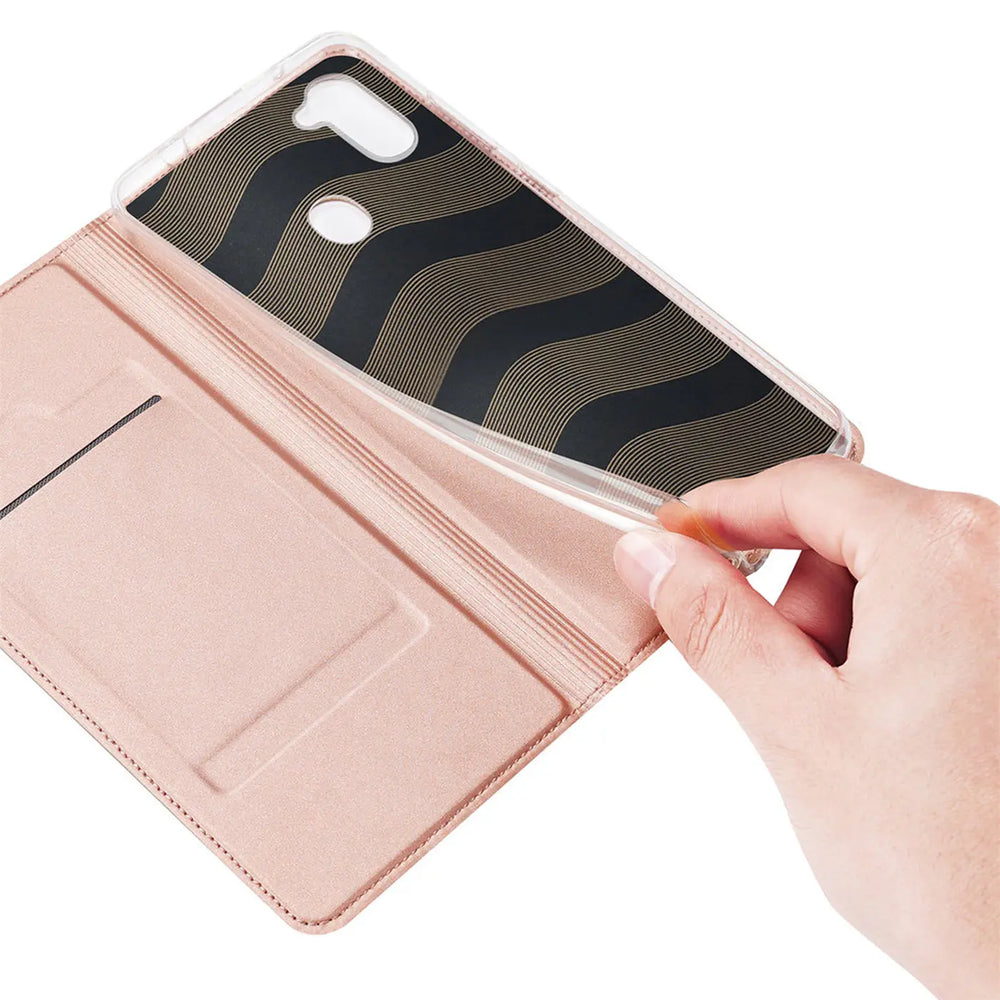 Hand hält eine offene, rosafarbene Kunstleder-Flip-Hülle für Samsung Galaxy M11 mit transparentem TPU-Inlay.