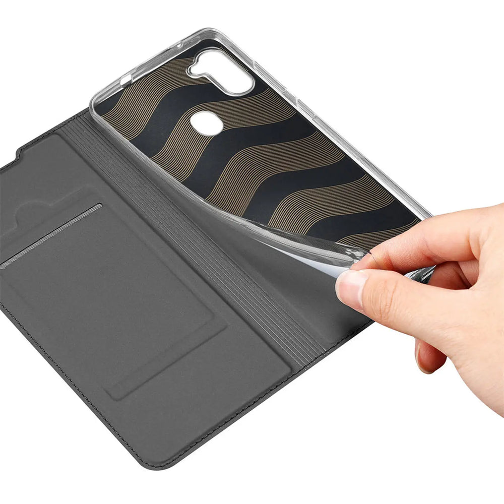 Hand hält transparente Silikonhülle für Samsung Galaxy M11 über geöffneter, dunkelgrauer Kunstleder-Flip-Hülle mit Fächern.