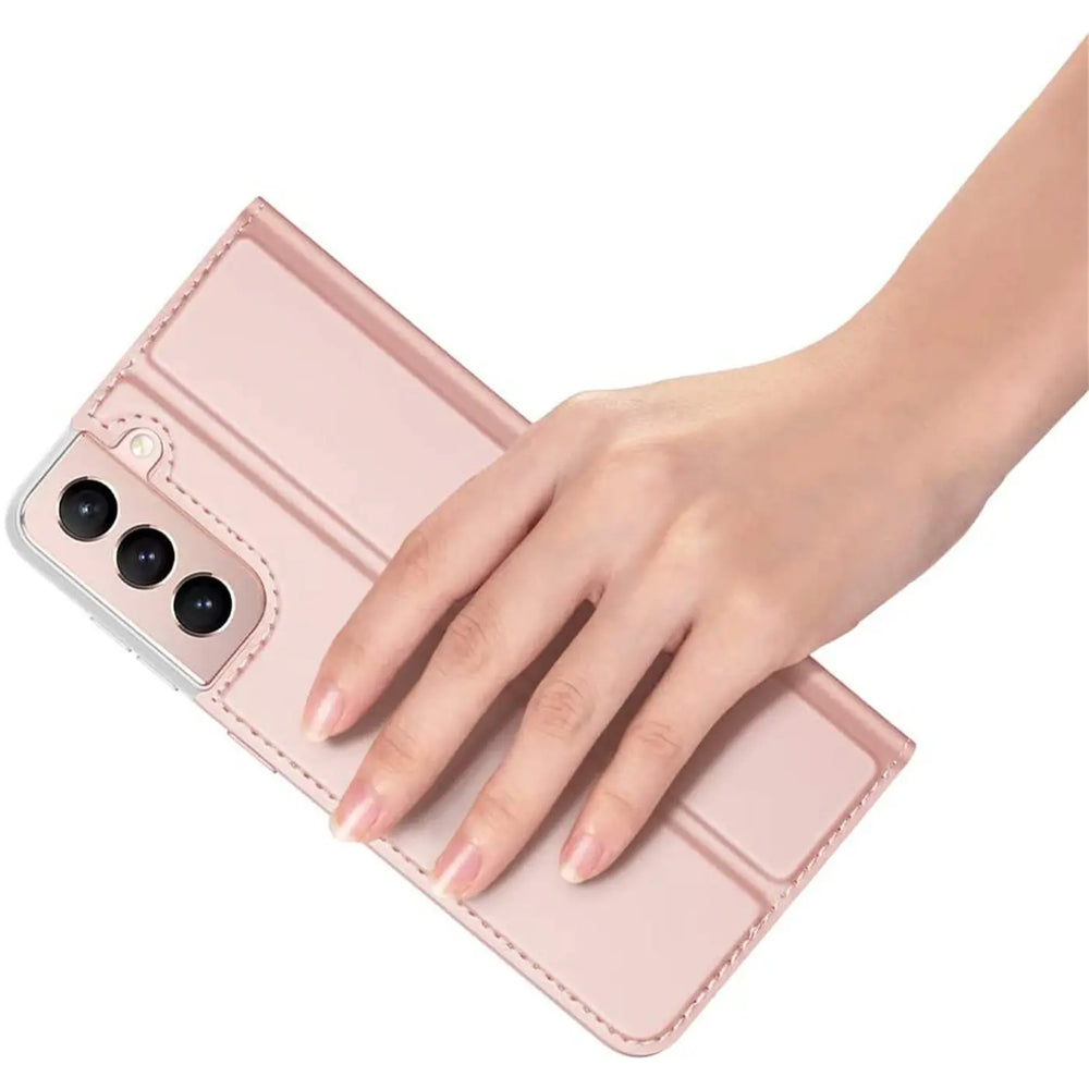 Frauenhand hält rosa Metallic Flip Hülle für Samsung Galaxy S21 FE, schräg von oben.
