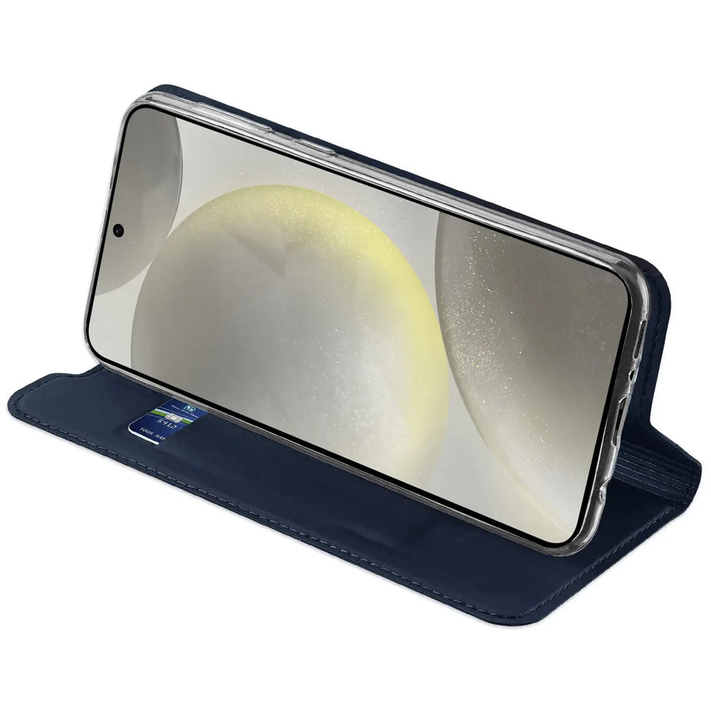 Samsung Galaxy S24 FE in dunkelblauer, klappbarer Kunstlederhülle, schräg von oben, mit Kreditkarte im Fach.