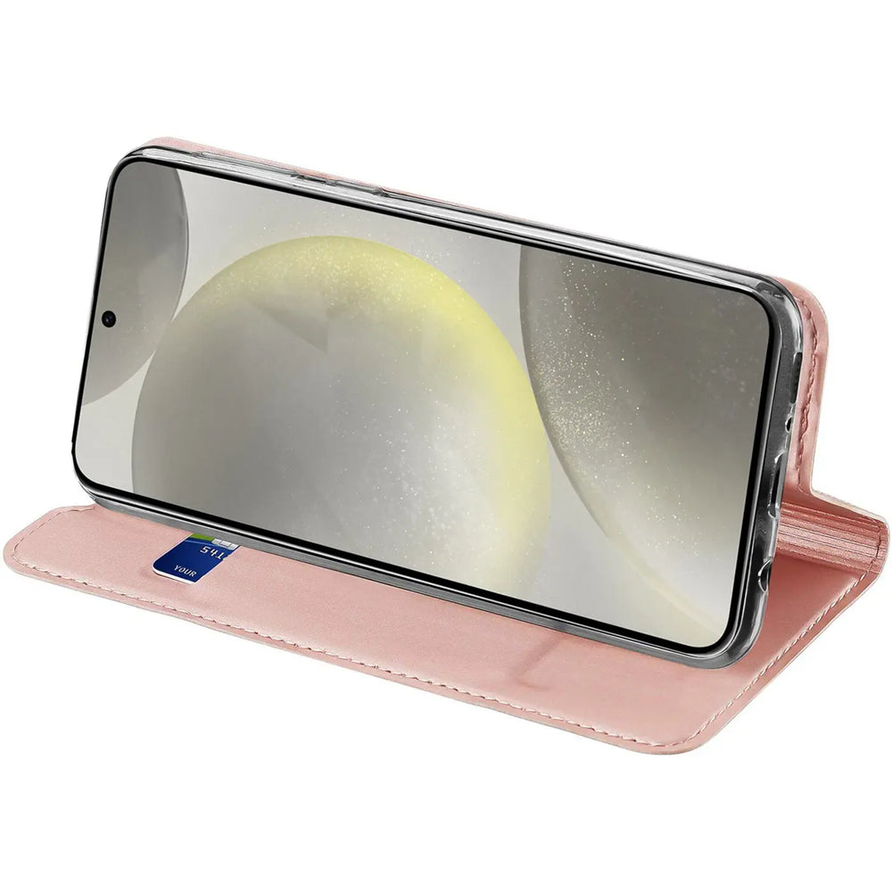 Samsung Galaxy S24 FE in rosafarbener, klappbarer Kunstlederhülle, schräg von vorne als Ständer aufgestellt.