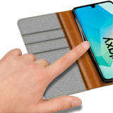 Graue Textil-Klapphülle mit braunen Lederdetails, Kartenfächern und Samsung Galaxy A27 5G.