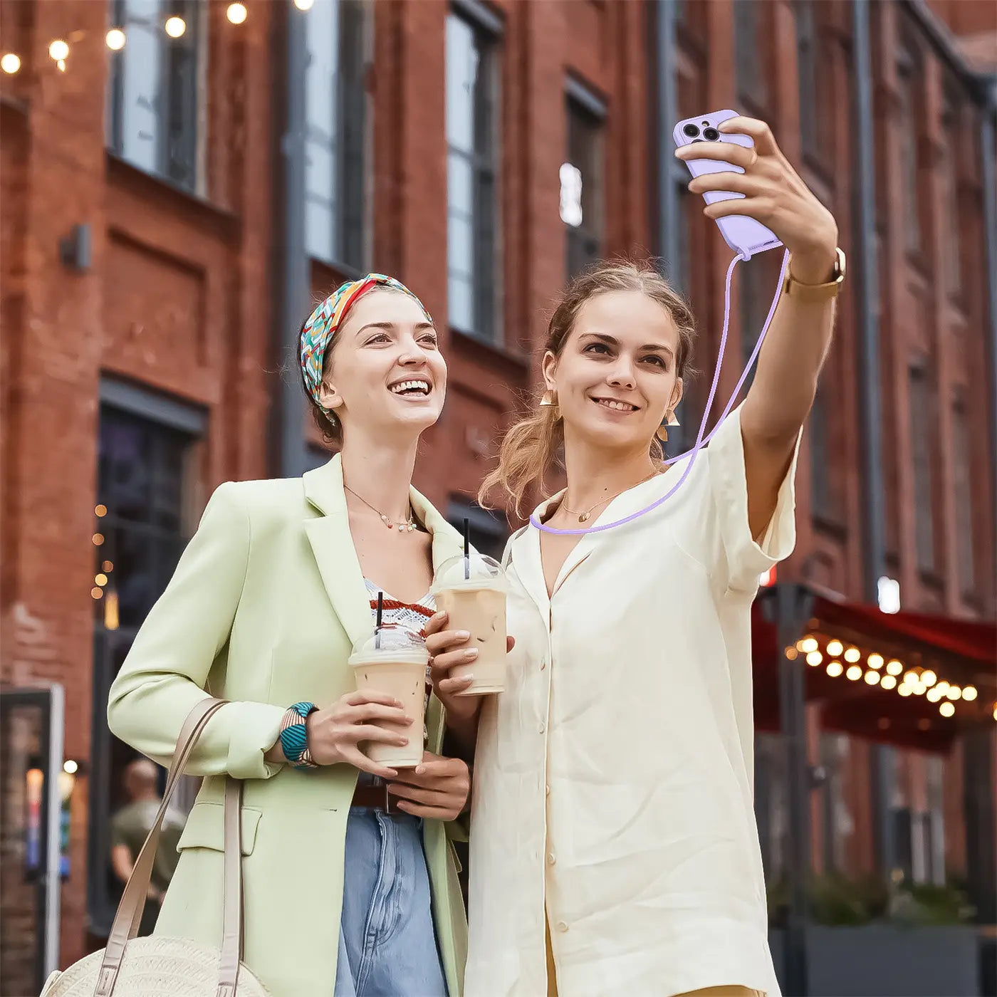 Frau nimmt Selfie mit lila iPhone 17 Pro Max mit Kette auf, Kameraschutz.