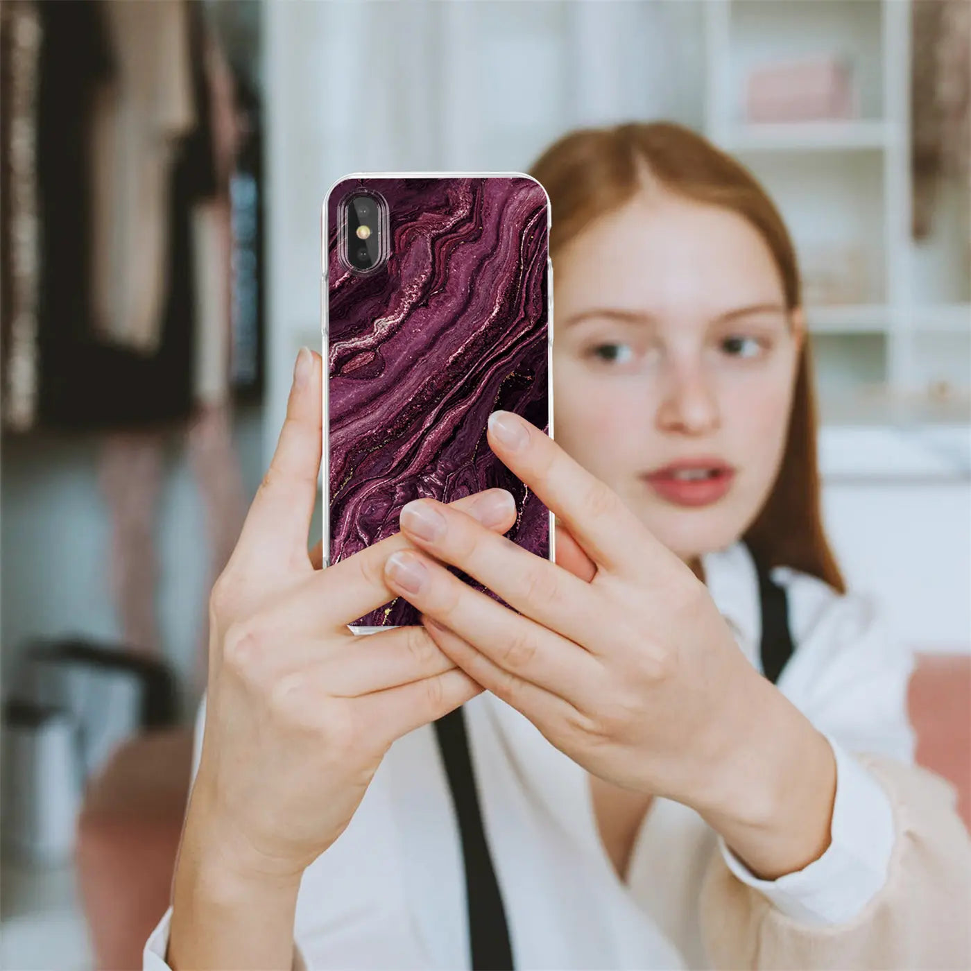 iPhone XR Hülle mit Marmor-Muster in Lila/Gold, von vorne, von einer Frau gehalten.