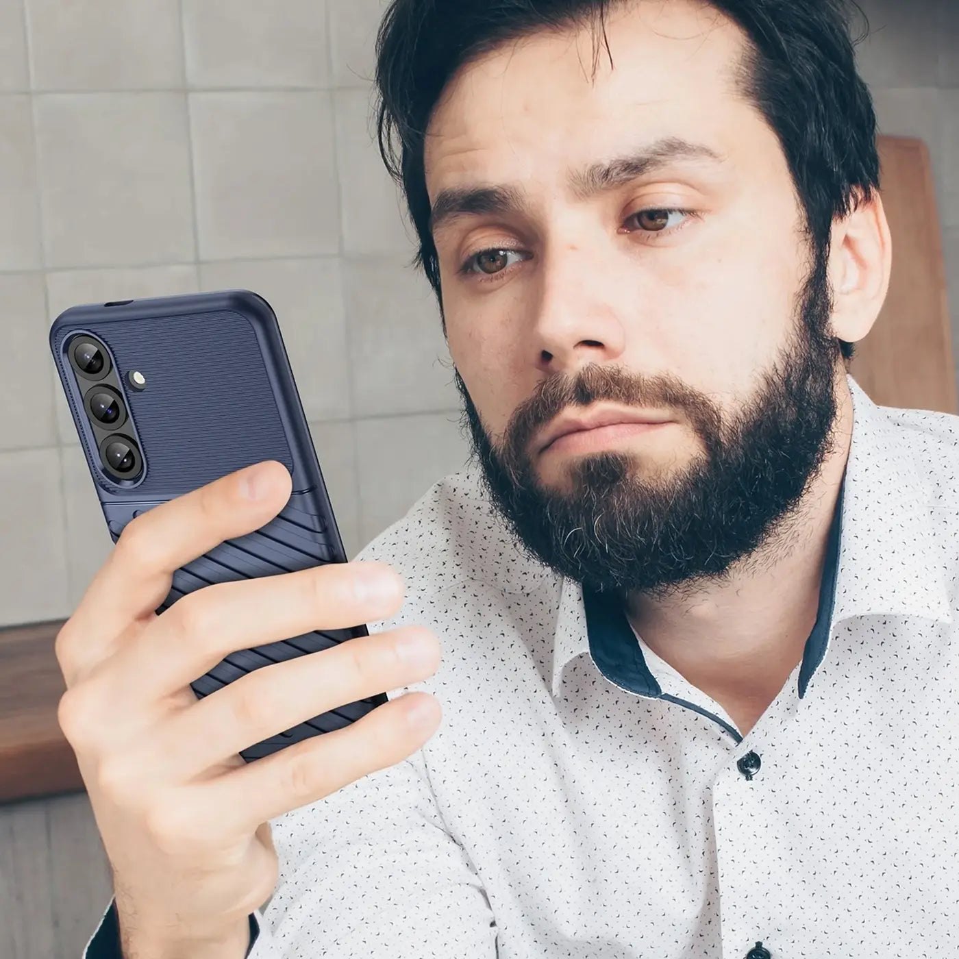 Dunkelblaue Handyhülle aus Kunststoff mit Rillenmuster, von vorne seitlich gezeigt, hält ein Samsung Galaxy S25.