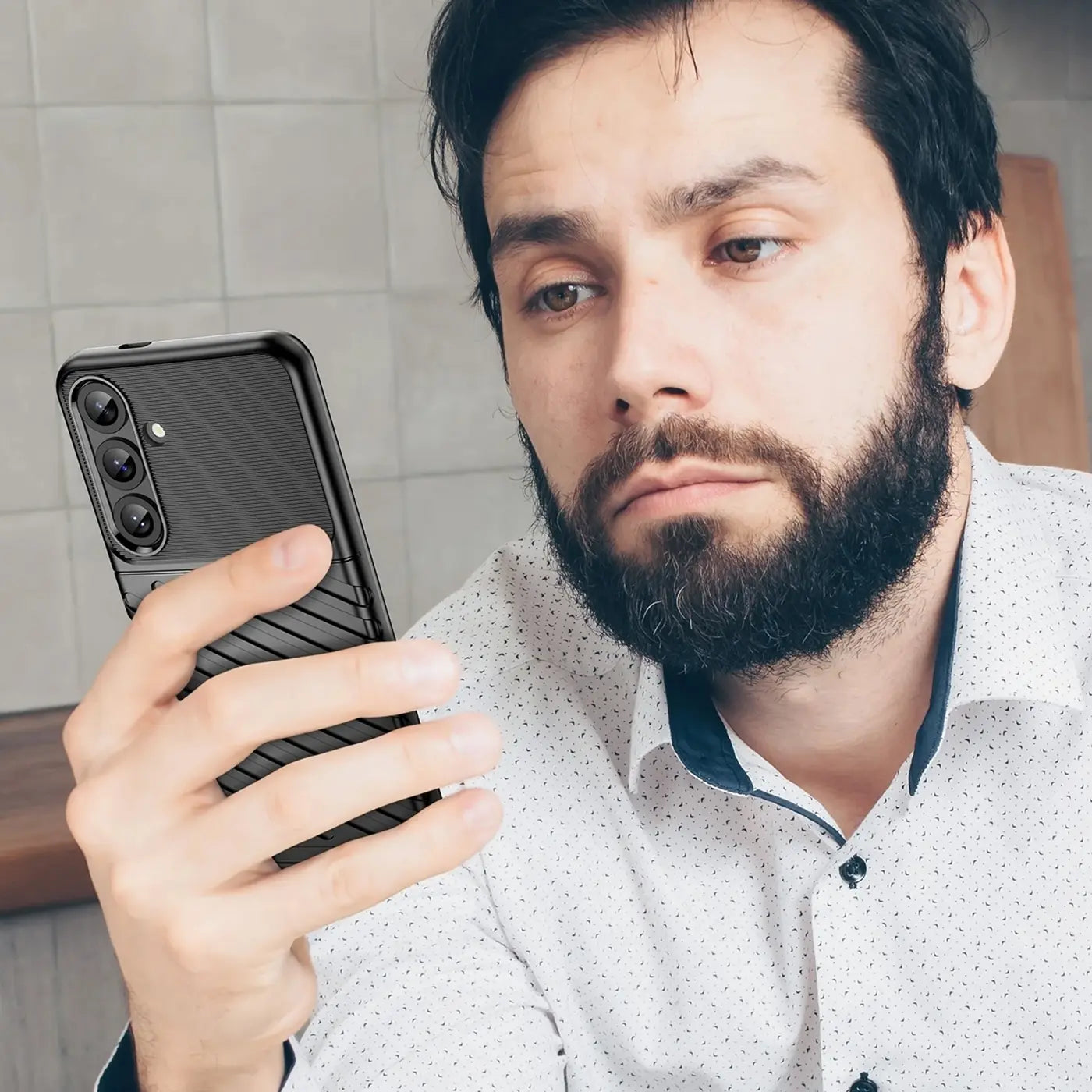 Schwarze Handyhülle aus Kunststoff mit Rillenmuster, seitliche Ansicht, hält ein Samsung Galaxy S25 Plus.