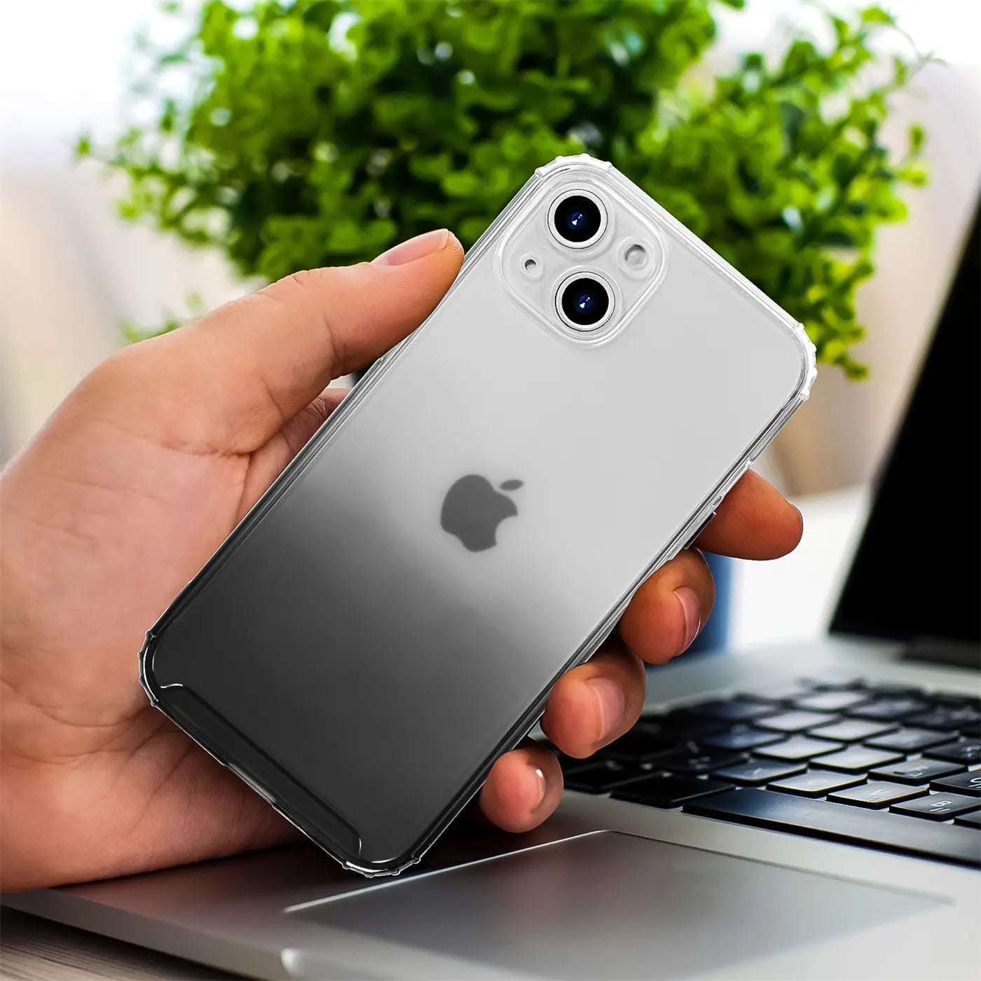 Hand hält iPhone 13 Mini mit transparenter Hülle, Farbverlauf grau, Nahaufnahme.