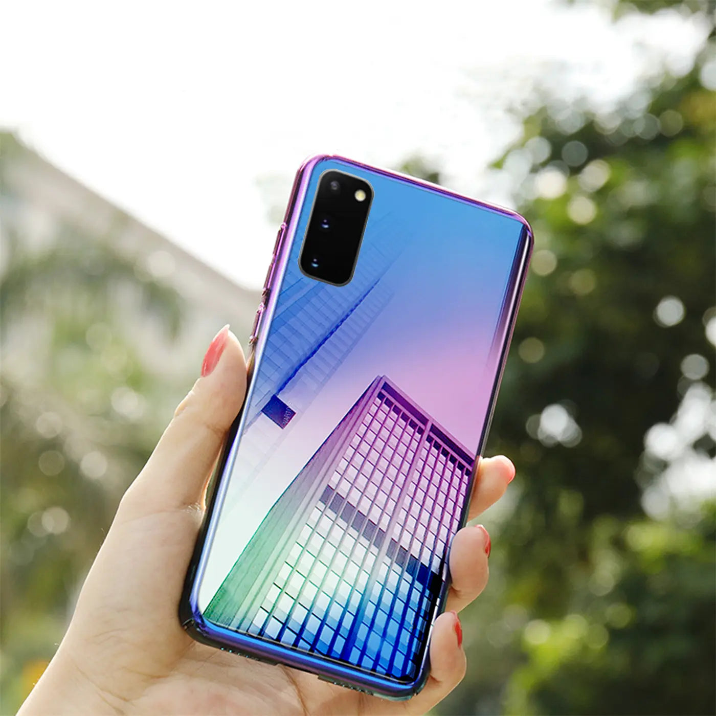 Hand hält iPhone 11 Pro Max mit blauer/pinker Farbverlauf-Hülle, spiegelnde Oberfläche.