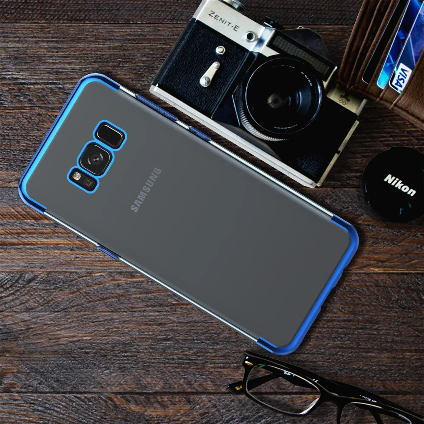 Samsung Galaxy S8 Plus in klarer Hülle mit blauem Rand, Rückansicht, auf Holz