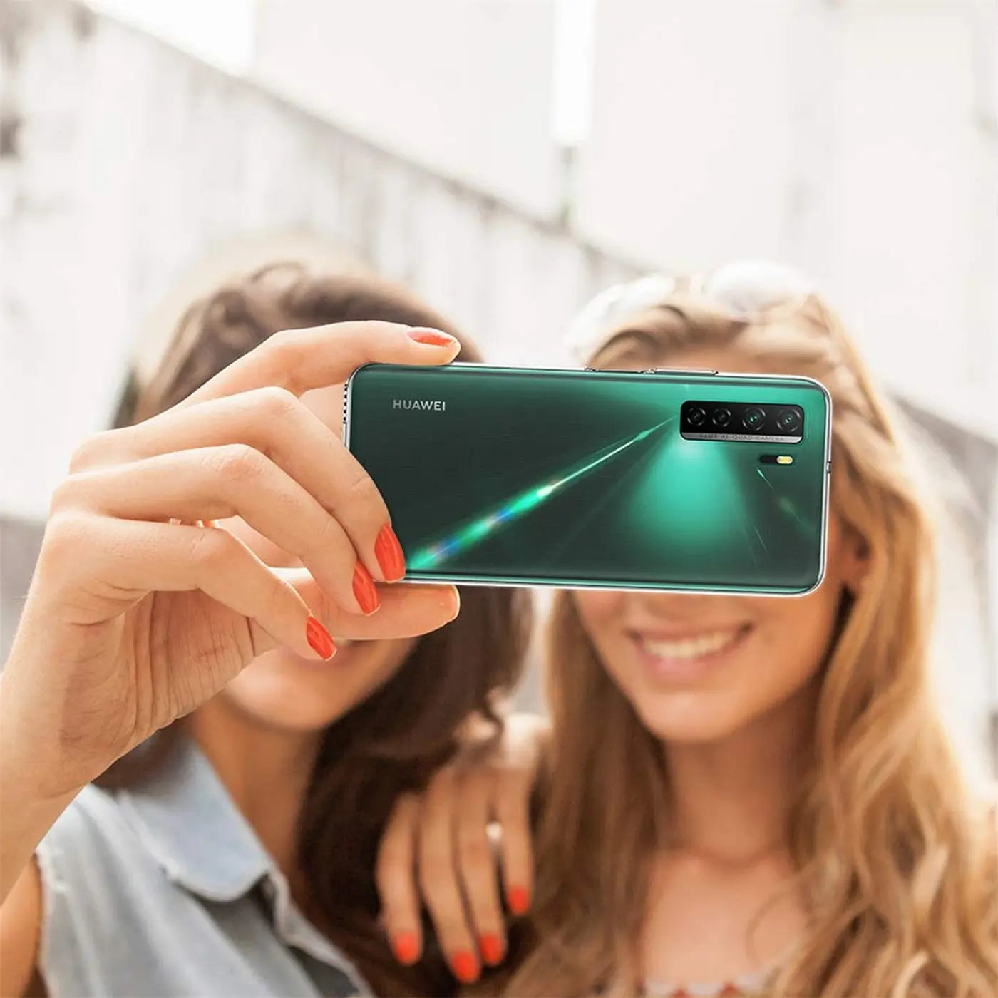 Grünes Huawei P40 Lite 5G, Rückseite, von vorne aufgenommen, mit zwei Frauen.