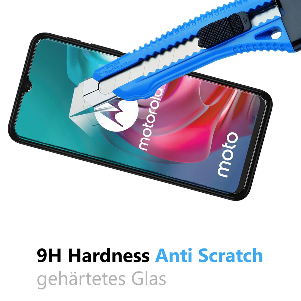 Blau-schwarzes Cuttermesser kratzt auf dem Displayschutz eines schwarzen Motorola Smartphones, schräg von oben.