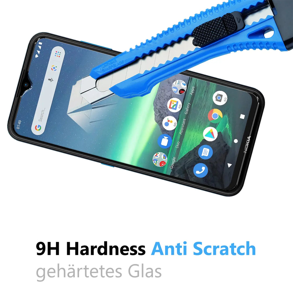 Blaues Cuttermesser kratzt auf dem Display eines Nokia 1.4 Smartphones, das mit Panzerglas geschützt ist.