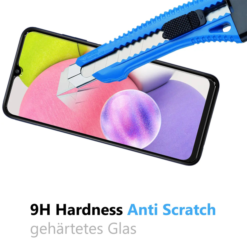 Blaues Cuttermesser auf Samsung Galaxy A03s Display mit Panzerglas, das Kratzer abwehrt. Von oben rechts.