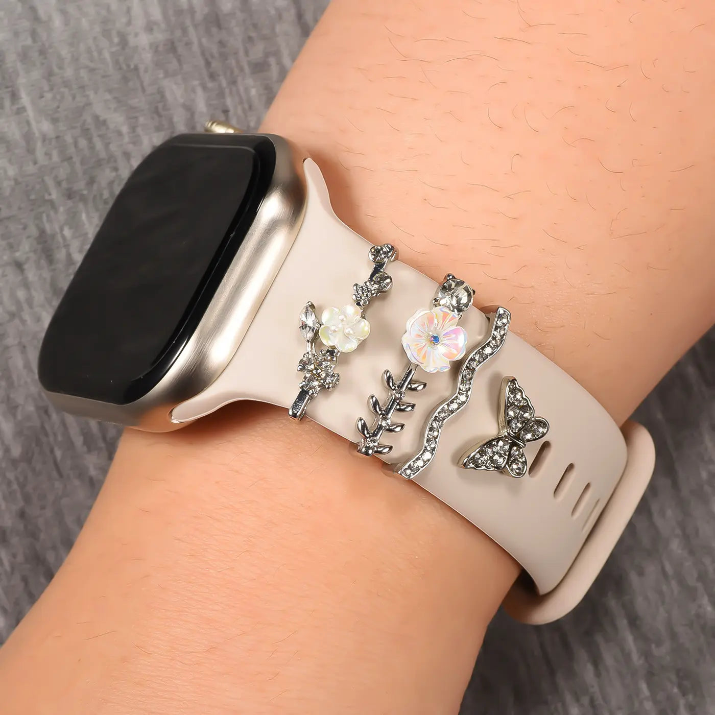 Smartwatch-Armband aus beigem Silikon mit silbernen Charms (Blumen, Zweige, Schmetterling).