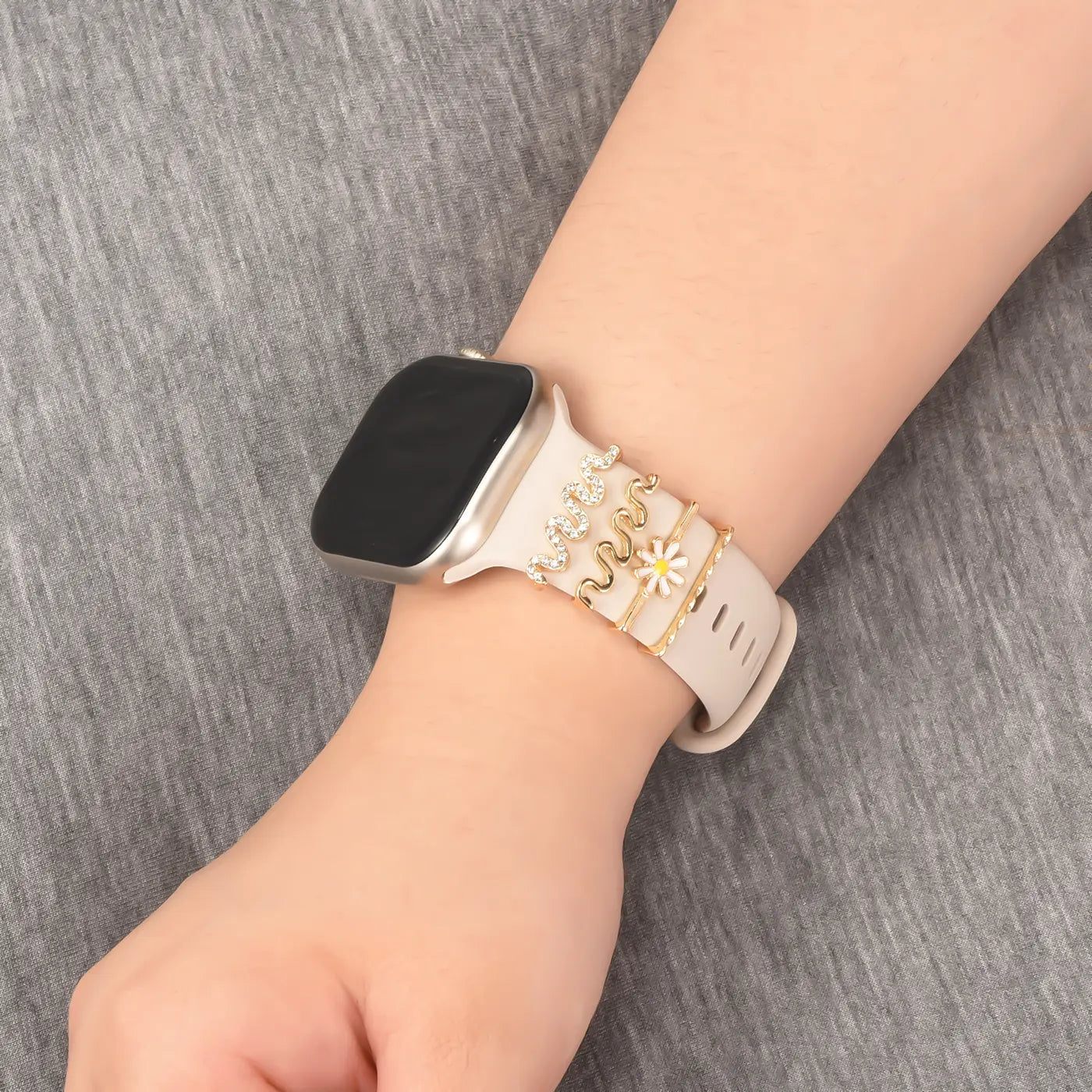 Beige Smartwatch-Armband mit goldenen Charms, Nahaufnahme von vorne