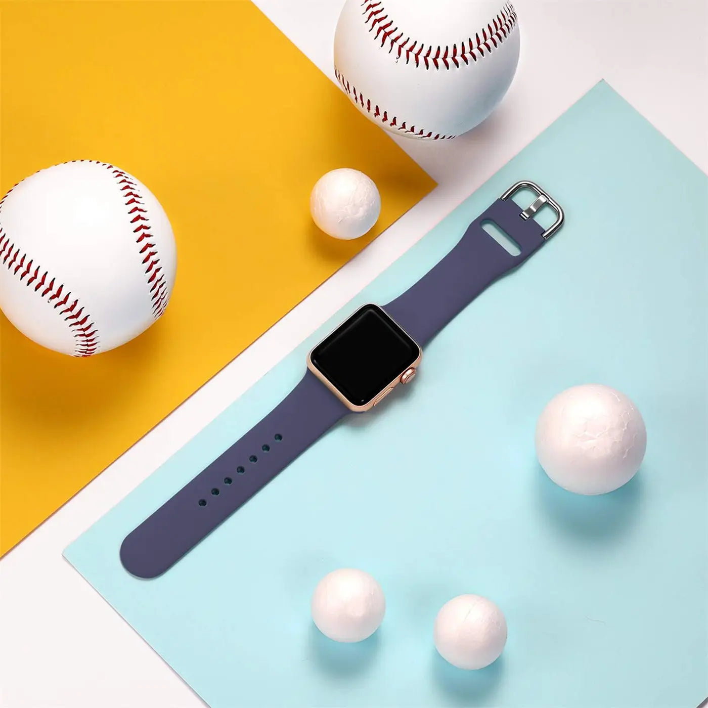 Dunkelblaues TPU-Fitnessarmband für Apple Watch, mit silberner Schnalle, von oben auf gelb-blauem Hintergrund.