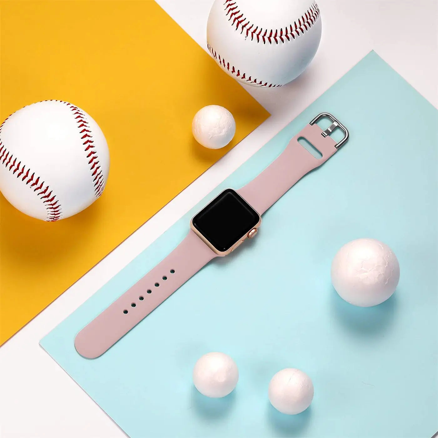 Rosafarbenes TPU-Fitnessarmband für Apple Watch, von oben auf blau-gelbem Hintergrund mit Basebällen.
