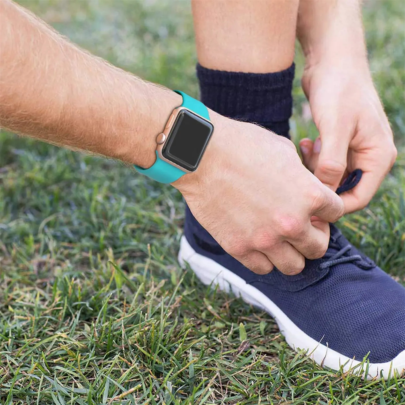 Person bindet Schnürsenkel. Am linken Handgelenk eine Apple Watch mit türkisem TPU-Armband, Nahaufnahme.