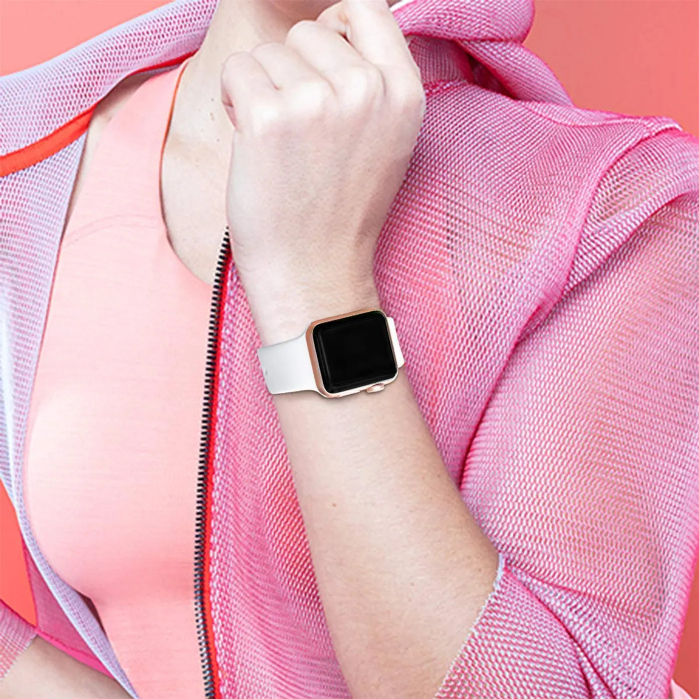 Arm einer Person mit weißem TPU-Fitnessarmband an einer goldenen Apple Watch, von oben.
