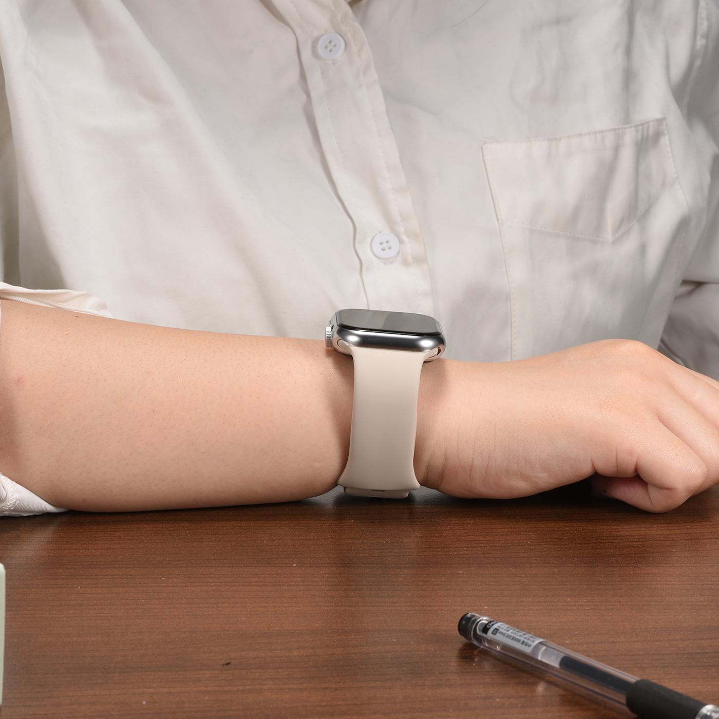 Beiges Silikonarmband mit Butterfly-Verschluss an Apple Watch, von vorne gesehen.